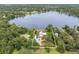 Stunning aerial view of lakeside property with lush landscaping and private dock on a clear blue lake at 13533 Bay Lake Ln, Tampa, FL 33618