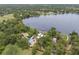 Aerial view of a lakeside estate, showing multiple homes, garages, dock, mature trees, and blue skies at 13533 Bay Lake Ln, Tampa, FL 33618