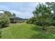 Lush backyard with green grass and screened-in patio, creating a private outdoor retreat at 13533 Bay Lake Ln, Tampa, FL 33618