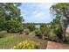 Beautiful backyard featuring a pond view, mature landscaping, and a wooden deck at 13533 Bay Lake Ln, Tampa, FL 33618