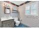 Patterned full bathroom with a single sink vanity and a window with wooden blinds at 13533 Bay Lake Ln, Tampa, FL 33618
