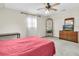 Well-lit bedroom featuring a ceiling fan and a window with wooden blinds at 13533 Bay Lake Ln, Tampa, FL 33618