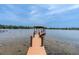 Picturesque view of the private dock extending into the serene lake, offering recreational opportunities at 13533 Bay Lake Ln, Tampa, FL 33618