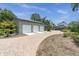 Brick paved driveway leading to a three-car garage and a two-car garage on a sunny day at 13533 Bay Lake Ln, Tampa, FL 33618