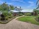 Well maintained single-story home featuring a brick paver walkway, lush landscaping, and a metal roof at 13533 Bay Lake Ln, Tampa, FL 33618