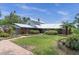 Charming brick home with a metal roof, well-manicured lawn, and beautiful landscaping under a bright sky at 13533 Bay Lake Ln, Tampa, FL 33618
