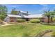Lovely exterior view of brick home featuring lush landscaping, metal roof, and inviting curb appeal at 13533 Bay Lake Ln, Tampa, FL 33618