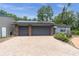 Spacious two-car garage featuring brick pillars, gray doors, solar panels and a brick paver drive way at 13533 Bay Lake Ln, Tampa, FL 33618