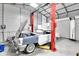 Well-lit garage featuring a vehicle lift and classic car at 13533 Bay Lake Ln, Tampa, FL 33618