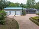 Brick paved driveway leading to a 3-car and a 2-car garage, tropical landscaping and mature trees at 13533 Bay Lake Ln, Tampa, FL 33618