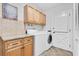 Convenient laundry room with granite countertop and wood cabinets, a washer, and a dryer at 13533 Bay Lake Ln, Tampa, FL 33618
