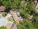 An aerial view of a well-maintained house with a circular driveway surrounded by lush greenery and mature trees at 1400 23Rd S Ave, St Petersburg, FL 33705