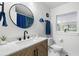 Bathroom with modern fixtures featuring wood cabinet vanity, round mirror, and natural light from a window at 1400 23Rd S Ave, St Petersburg, FL 33705