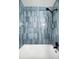 Modern bathtub with blue, decorative tiling and black fixtures at 1400 23Rd S Ave, St Petersburg, FL 33705