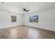 Spacious bedroom with hardwood floors, white walls, ceiling fan, and large windows overlooking the street at 1400 23Rd S Ave, St Petersburg, FL 33705