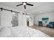 Large bedroom features white walls and bedding, along with sliding barn doors to the ensuite bathroom at 1400 23Rd S Ave, St Petersburg, FL 33705