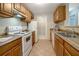 Efficient kitchen with tile floor, ample wood cabinets, and modern white appliances for easy meal preparation at 1400 Gandy N Blvd # 1504, St Petersburg, FL 33702
