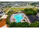 Aerial view showcasing community pool, playground, clubhouse, and surrounding neighborhood at 14614 Rannoch Moor Pl, Wimauma, FL 33598