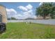 Lush backyard with a neat lawn, privacy fence, and an inviting fire pit area at 14614 Rannoch Moor Pl, Wimauma, FL 33598