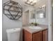 Bright bathroom featuring a vanity with cabinet storage and modern geometric wall decor at 14614 Rannoch Moor Pl, Wimauma, FL 33598