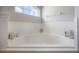Bright bathroom featuring a large soaking tub with tile surround and decorative accents at 14614 Rannoch Moor Pl, Wimauma, FL 33598