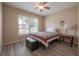 Inviting bedroom with a cozy quilt bed, a large window, and stylish wood-look flooring at 14614 Rannoch Moor Pl, Wimauma, FL 33598