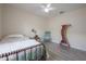 Bedroom with a comfortable bed, ceiling fan, chair, and a decorative shelf at 14614 Rannoch Moor Pl, Wimauma, FL 33598