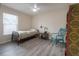 Bright bedroom with a comfy single bed, chair, side table, and a window at 14614 Rannoch Moor Pl, Wimauma, FL 33598