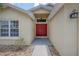 Inviting entryway featuring a red double door and well-kept landscaping at 14614 Rannoch Moor Pl, Wimauma, FL 33598
