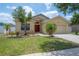 Charming single-story home featuring a well-maintained lawn and a welcoming red front door at 14614 Rannoch Moor Pl, Wimauma, FL 33598