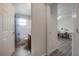 Hallway view showing access to a well-lit bathroom and a cozy bedroom at 14614 Rannoch Moor Pl, Wimauma, FL 33598