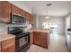 Open kitchen featuring a black oven, microwave, and view into the dining area at 14614 Rannoch Moor Pl, Wimauma, FL 33598