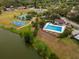 Aerial view features a community pool, a splash pad, tennis courts, basketball court, and the lake at 15301 Morning Dr, Lutz, FL 33559