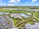 An aerial view shows a stunning clubhouse, swimming pool, and lush landscaping in this active adult community at 15817 San Lazzaro Ave, Bradenton, FL 34211