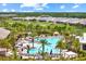 An aerial view of a community swimming pool surrounded by lounge chairs, palm trees, and well-maintained landscaping at 15817 San Lazzaro Ave, Bradenton, FL 34211