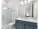 Contemporary bathroom with a glass shower, a white vanity, and blue cabinets at 15817 San Lazzaro Ave, Bradenton, FL 34211