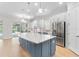 Modern kitchen featuring a large island, stainless steel appliances, and a view of the pool area at 15817 San Lazzaro Ave, Bradenton, FL 34211
