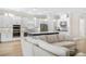 Spacious open-concept kitchen with white cabinets, stainless steel appliances, and a large blue island at 15817 San Lazzaro Ave, Bradenton, FL 34211