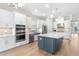 Open kitchen with a large island, stainless appliances, bright white cabinets, and pendant lighting at 15817 San Lazzaro Ave, Bradenton, FL 34211