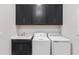 The well-equipped laundry room features cabinets, a countertop sink, and a white washer and dryer at 15817 San Lazzaro Ave, Bradenton, FL 34211