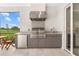 Outdoor kitchen with granite counters, stainless steel grill and plenty of storage and a doorway to interior at 15817 San Lazzaro Ave, Bradenton, FL 34211