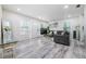 Well-lit living room featuring wood floors, a sofa, and a contemporary glass table at 1608 E Linden Ave, Tampa, FL 33604