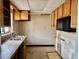 Functional kitchen featuring wood cabinets and essential appliances, ready for a new owner's touch at 17595 1St E St, Redington Shores, FL 33708