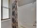 Shower/tub with patterned shower curtain beside a window with blinds at 17711 Hampshire Oak Dr, Tampa, FL 33647