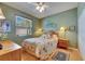 Comfortable bedroom with a floral bedspread, wood furniture, and natural light from the window at 17711 Hampshire Oak Dr, Tampa, FL 33647
