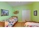 Twin bedroom with vibrant green walls, ceiling fan, and two matching wooden beds at 17711 Hampshire Oak Dr, Tampa, FL 33647