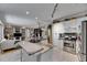Well-lit kitchen with granite counters, stainless steel appliances, white cabinets, and seamless flow into the living area at 17711 Hampshire Oak Dr, Tampa, FL 33647
