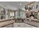 Open kitchen boasts granite counters, stainless steel sink, white cabinetry, and seamless flow to the living area and pool at 17711 Hampshire Oak Dr, Tampa, FL 33647