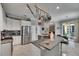 Open kitchen with white cabinets, stainless steel appliances, granite counters, and a breakfast bar with pendant lighting at 17711 Hampshire Oak Dr, Tampa, FL 33647