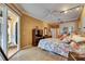 Bright main bedroom with a sliding glass door leading to an outdoor area and colorful floral bedspread at 17711 Hampshire Oak Dr, Tampa, FL 33647